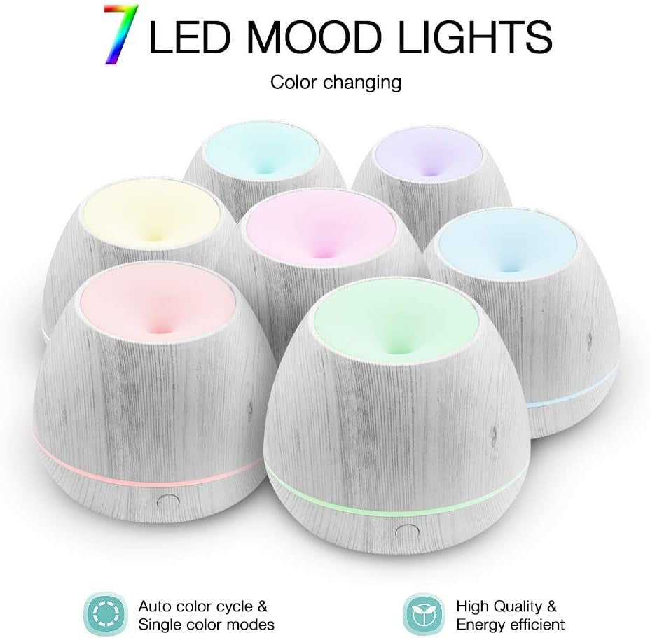 Essential oil humidifier emitting a fine mist from its top with a smooth, modern design and visible water vapor