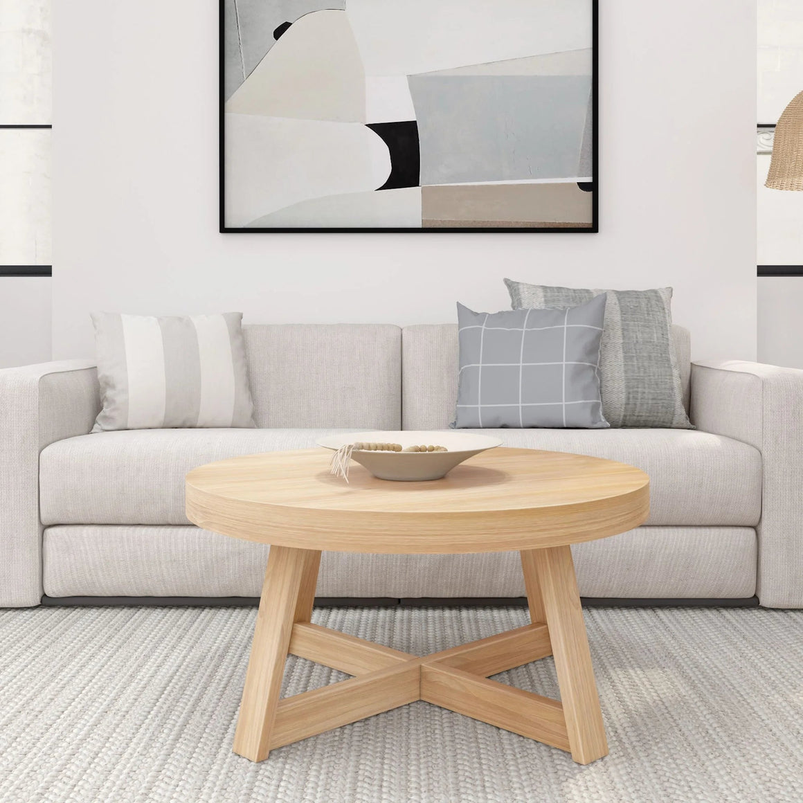 Round farmhouse coffee table with rustic wood top and metal base placed in a cozy living room setup